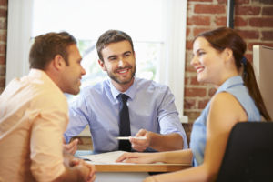 Couple Meeting With Financial Advisor In Office